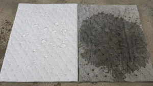 Water beading on a white oil only pad while soaking into a grey universal pad